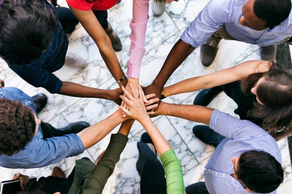 Team Of Diverse Workers Put Hands Together